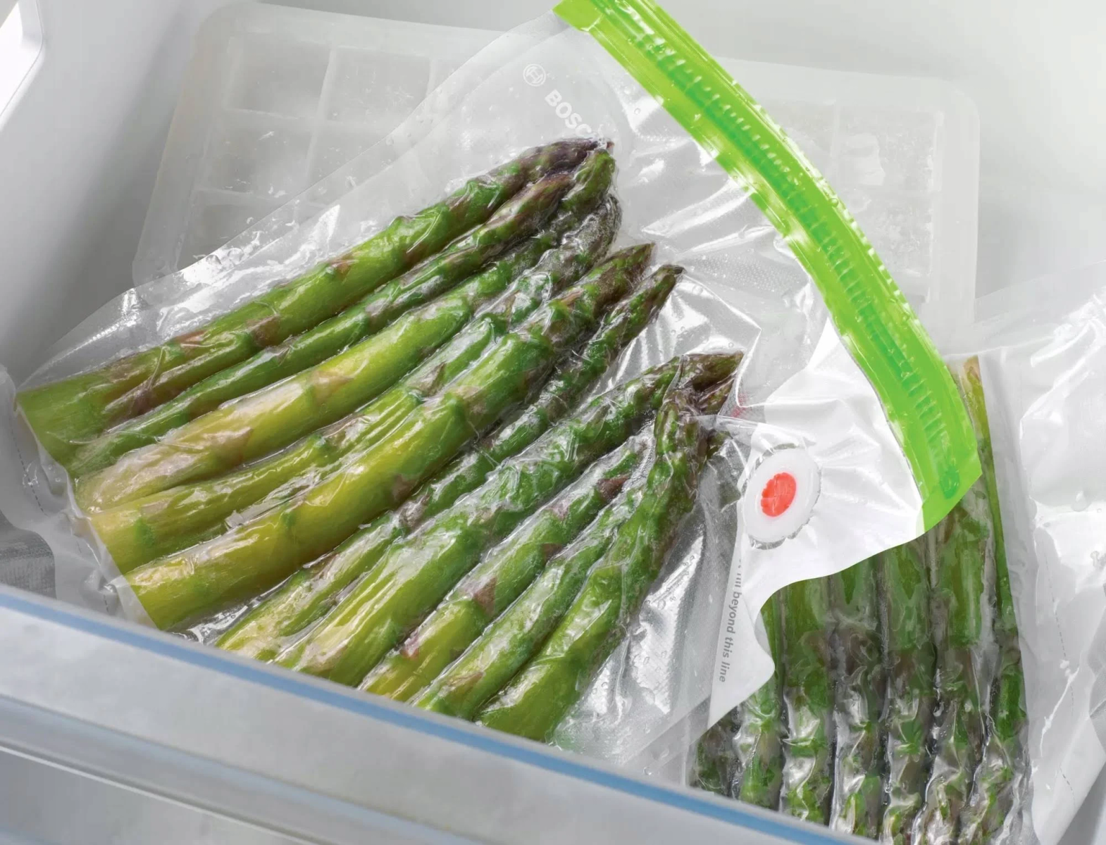 Spargel in einem vakuumversiegelten Beutel im Kühlschrank mit Eiswürfeln.
