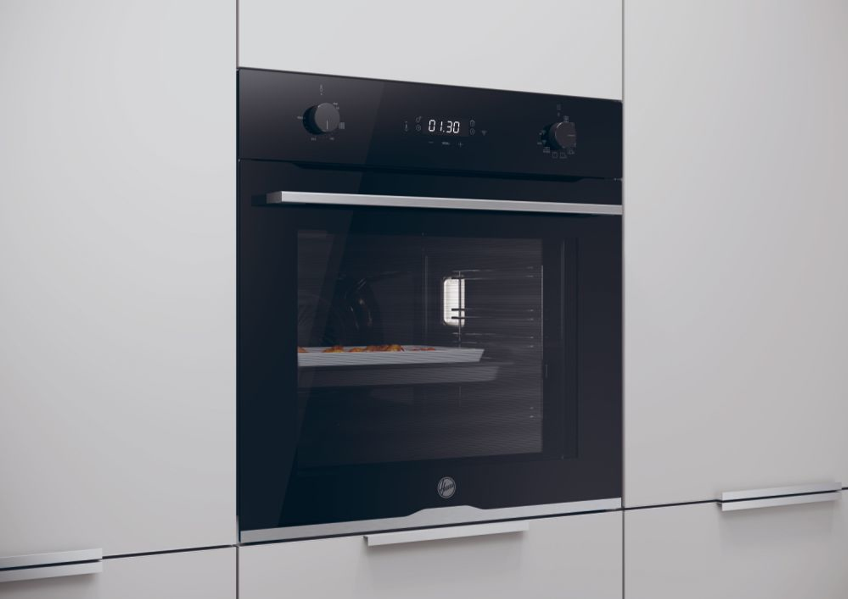 Forno nero integrato in un mobile da cucina bianco, con cibo all'interno.