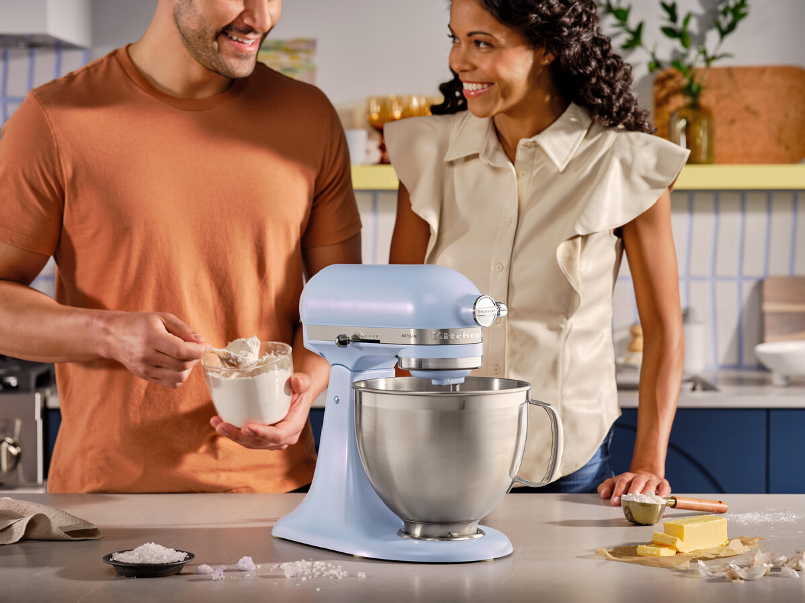 Una coppia cucina con un mixer KitchenAid azzurro.
