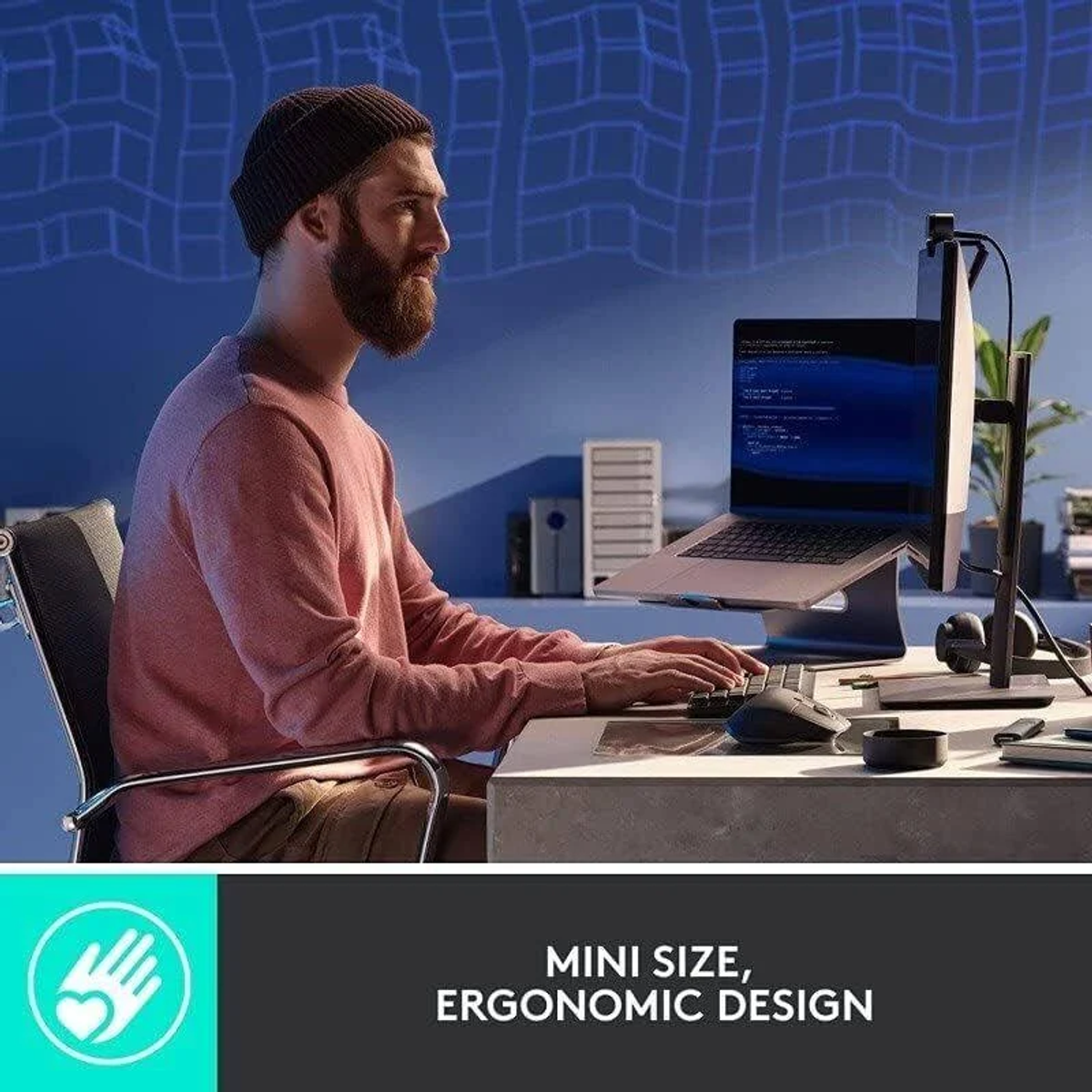 Mężczyzna z brodą pracuje na laptopie podłączonym do monitora, z tekstem o ergonomicznym designie.