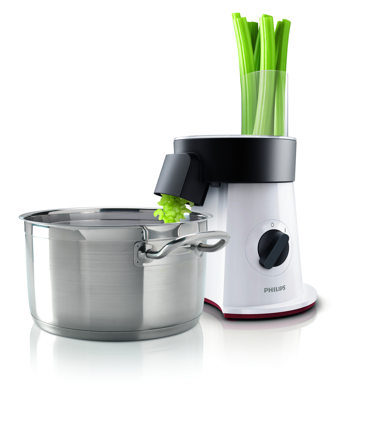 A white and black food processor with celery stalks in the top and a pot below.