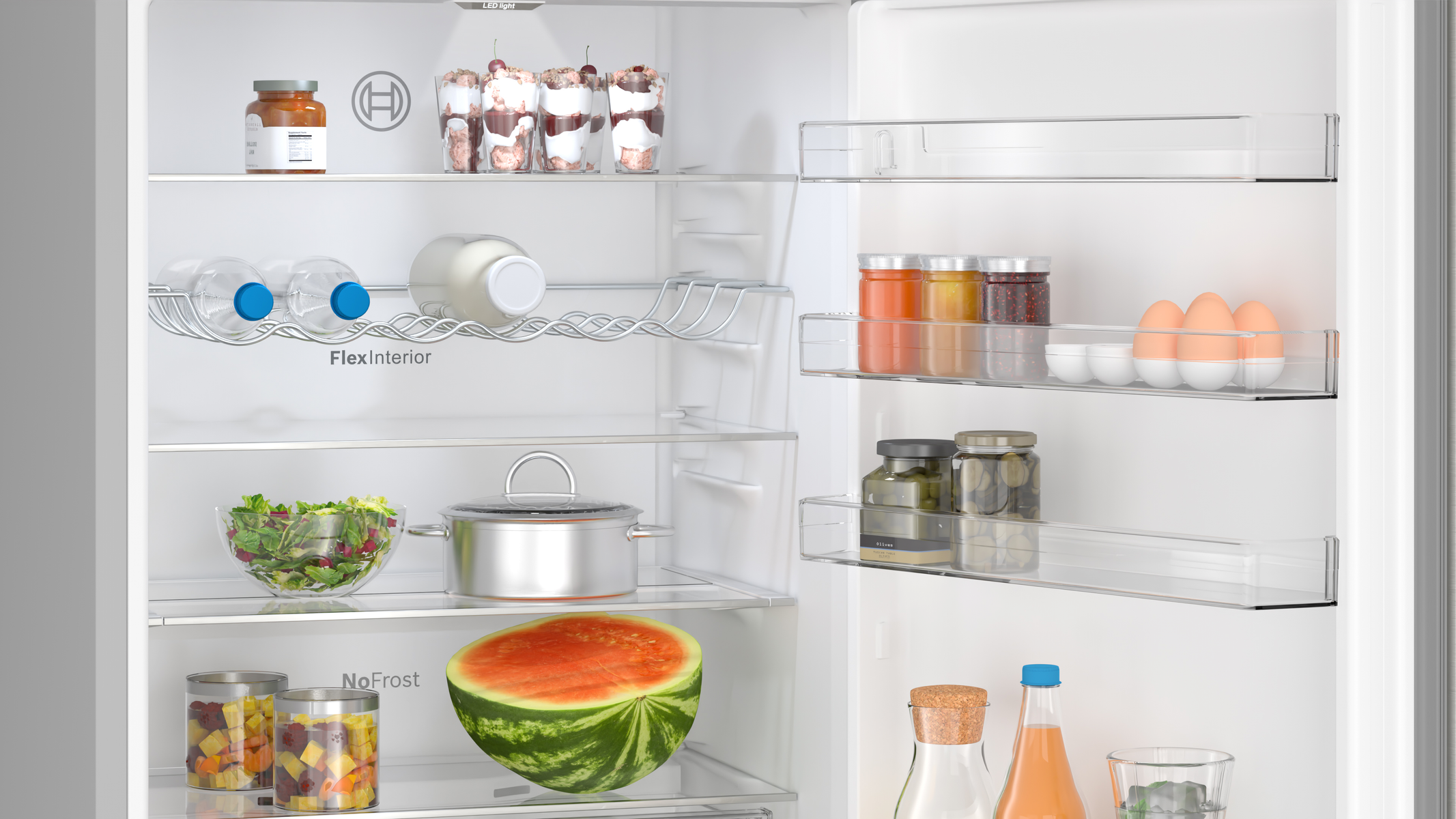 Otwarta lodówka z różnymi produktami spożywczymi, w tym arbuzem.