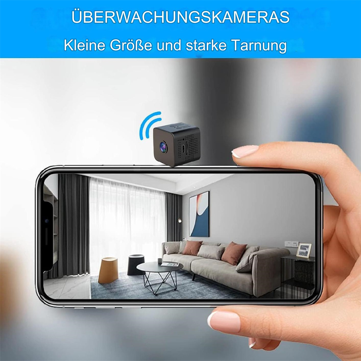 Eine kleine schwarze Überwachungskamera wird an einem Telefon hochgehalten, das ein Wohnzimmer zeigt.