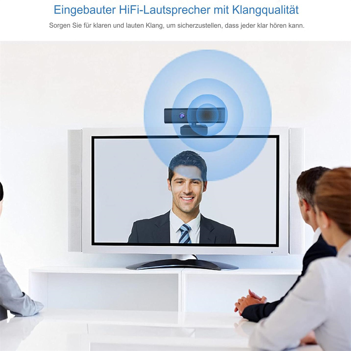 Eine Webcam auf einem Fernsehbildschirm mit drei Personen in einem Raum. Der Hintergrund ist eine weiße Wand.