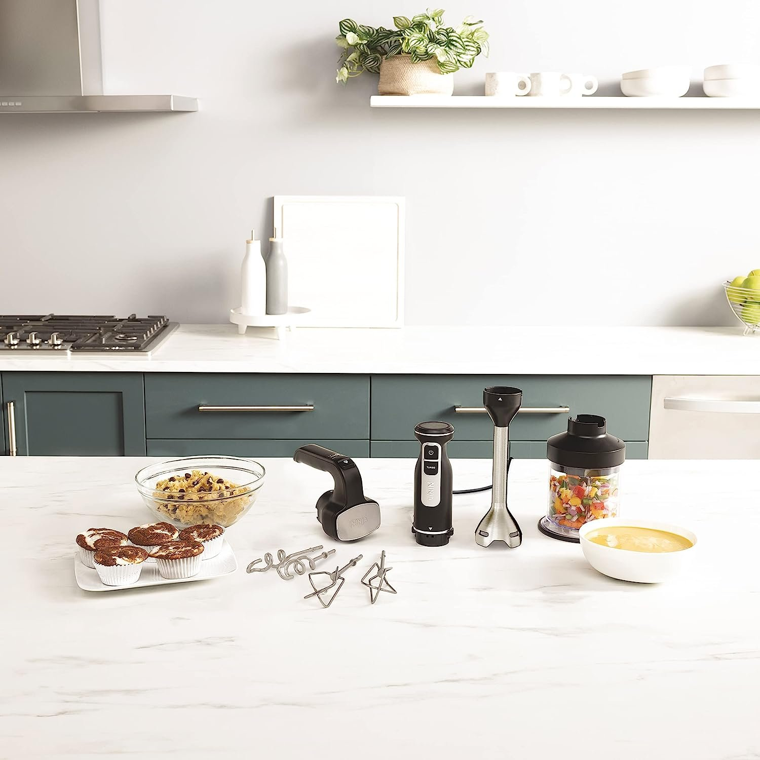 Küchentheke mit Mixer, Mischer, Zutaten und Backwaren.
