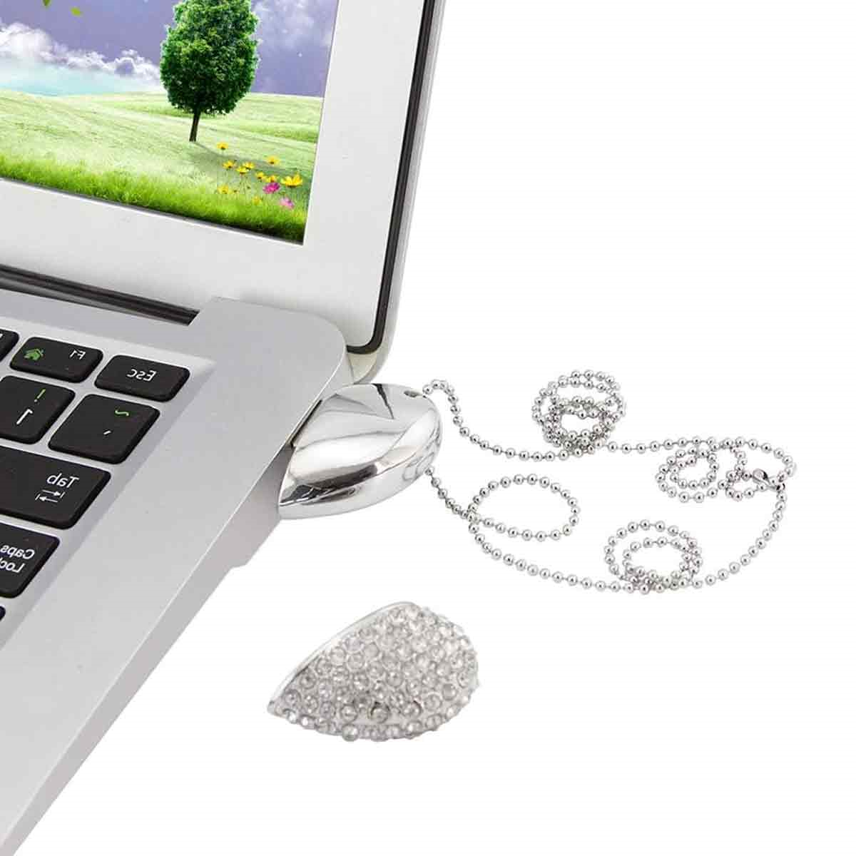 Silberner USB-Stick in einem Laptop, mit dekorativem Anhänger.