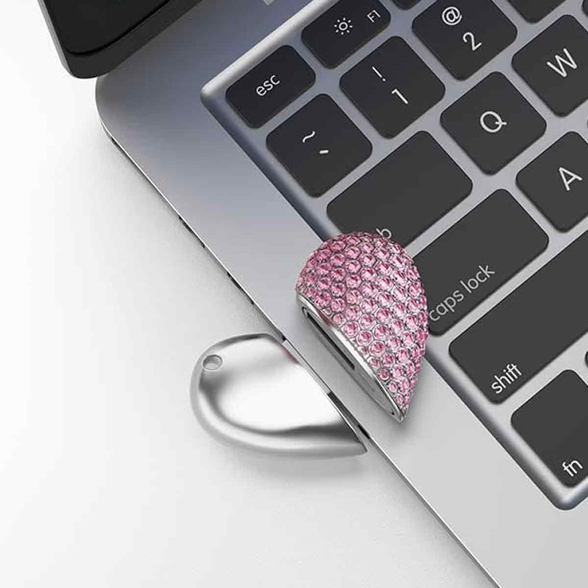 Ein bling herzförmiger Telefonring auf einer Laptop-Tastatur.