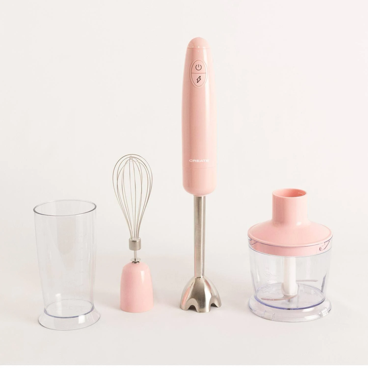 Batidora de mano rosa con accesorios: vaso, batidor y picador sobre fondo blanco.
