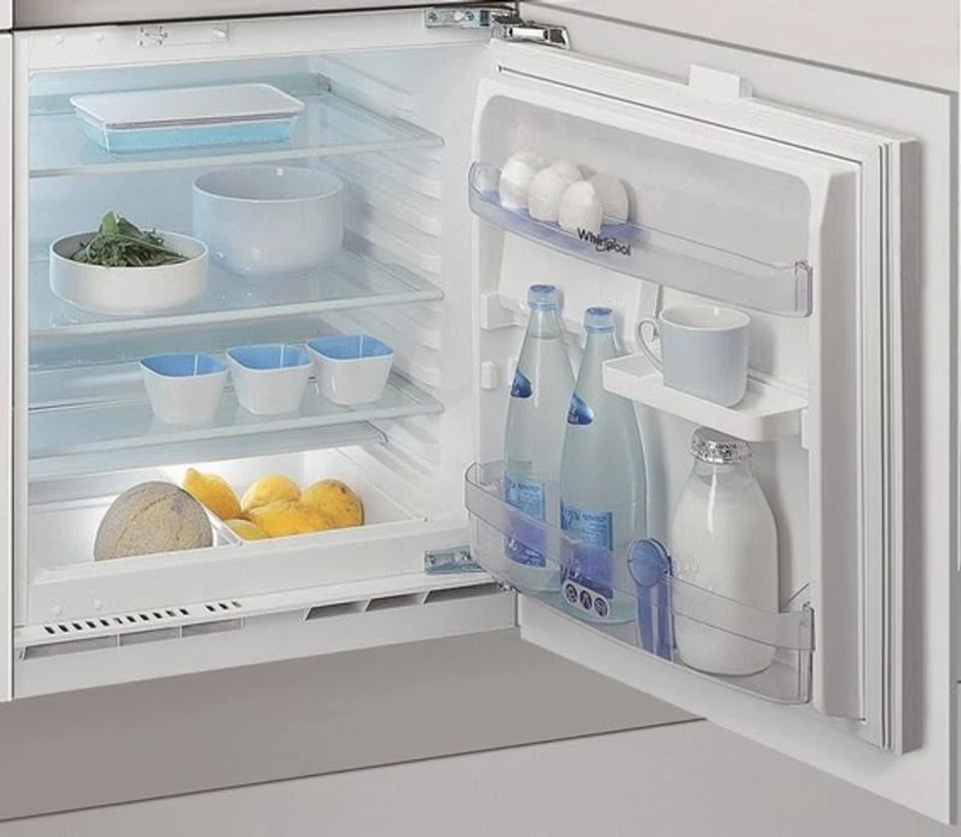 Un interno frigorifero bianco con generi alimentari e ripiani, la porta è aperta.