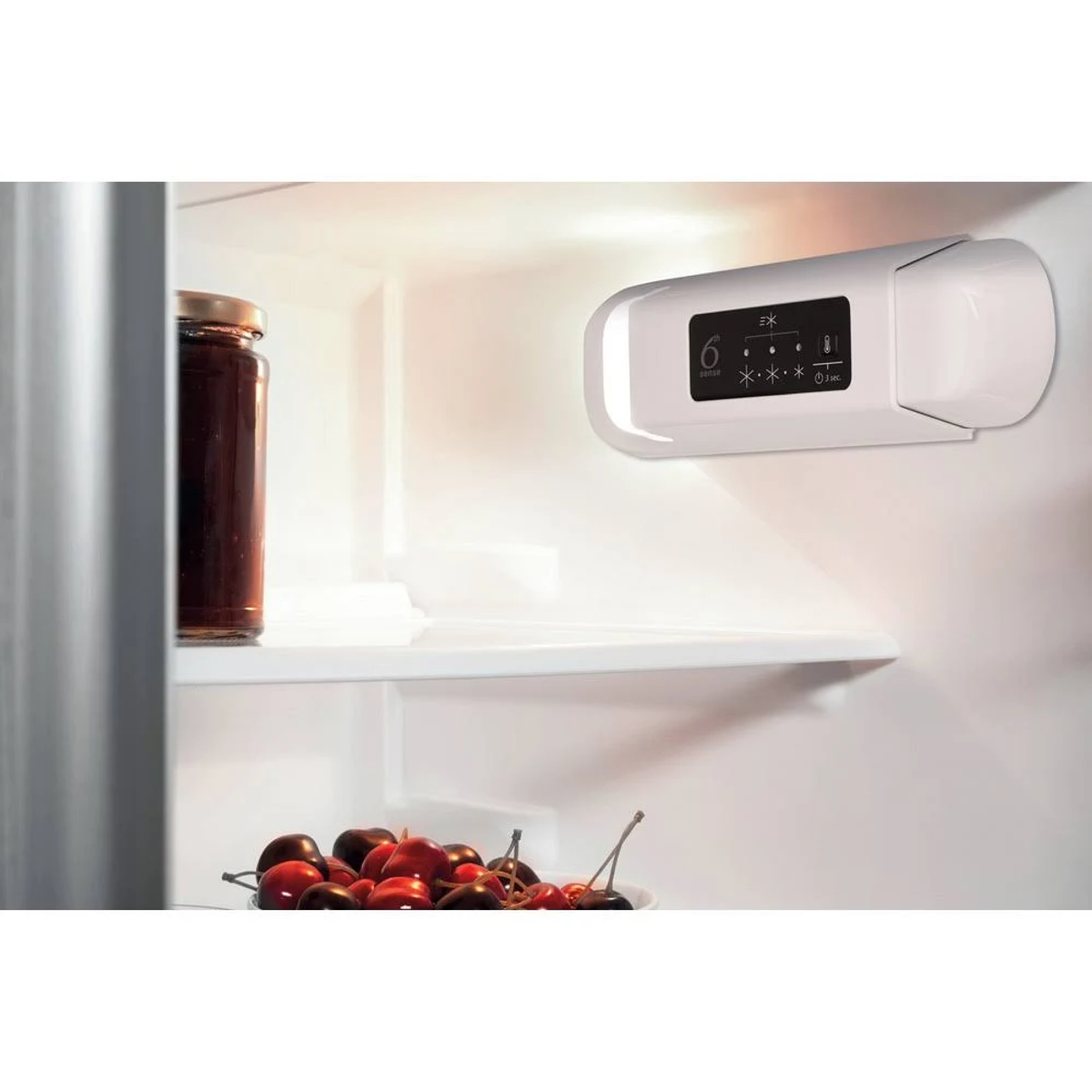 Interno frigo con barattolo, ciliegie e pannello di controllo digitale.