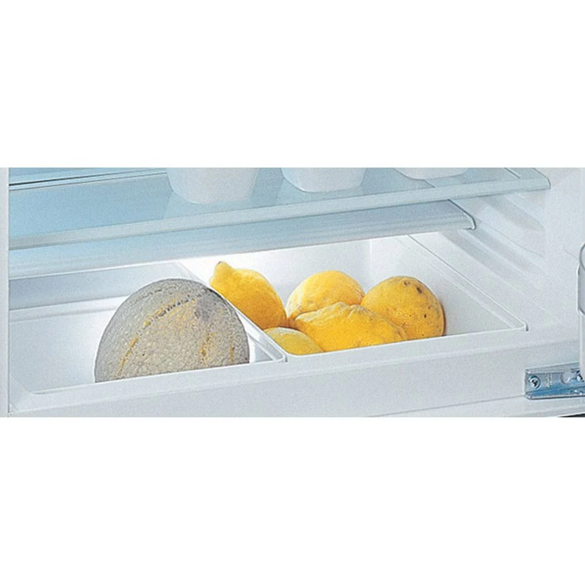 Cassetto del frigorifero con melone e limoni.