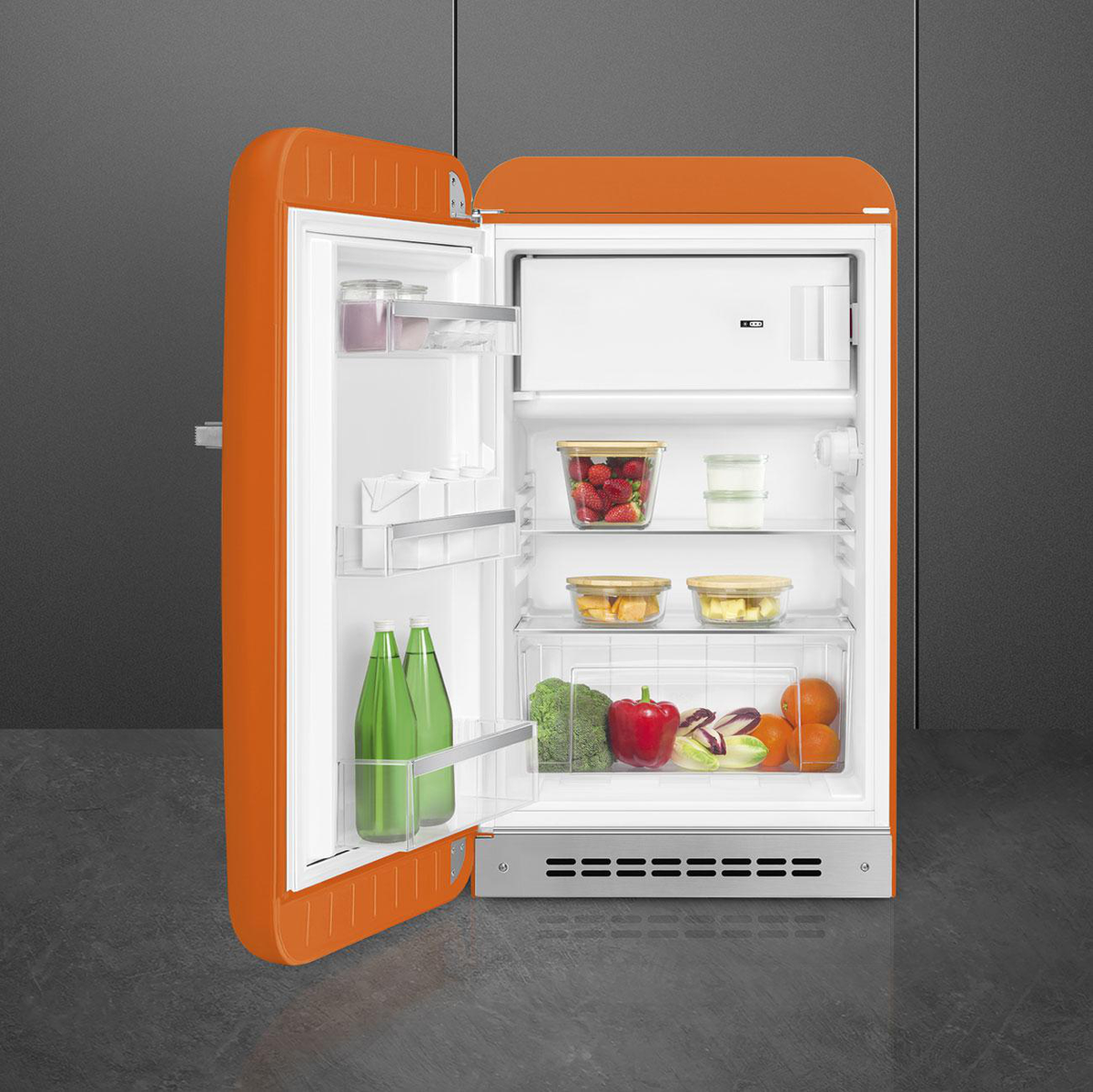 Refrigerador naranja estilo retro con la puerta abierta. Dentro hay alimentos.