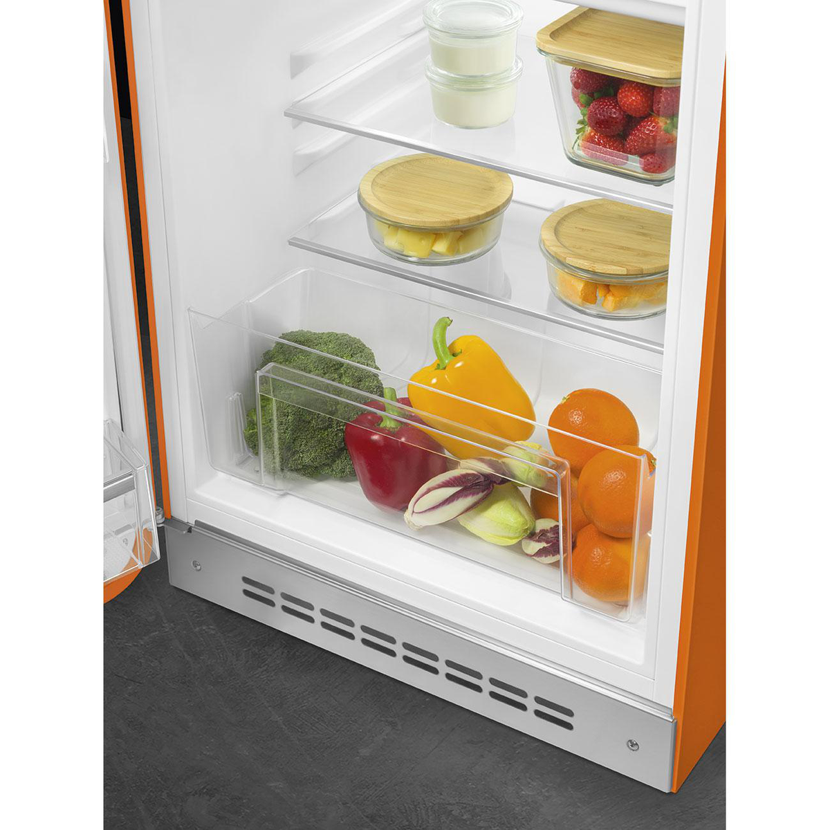 Interior del refrigerador con frutas y verduras. Varios artículos se almacenan en cajones y recipientes.