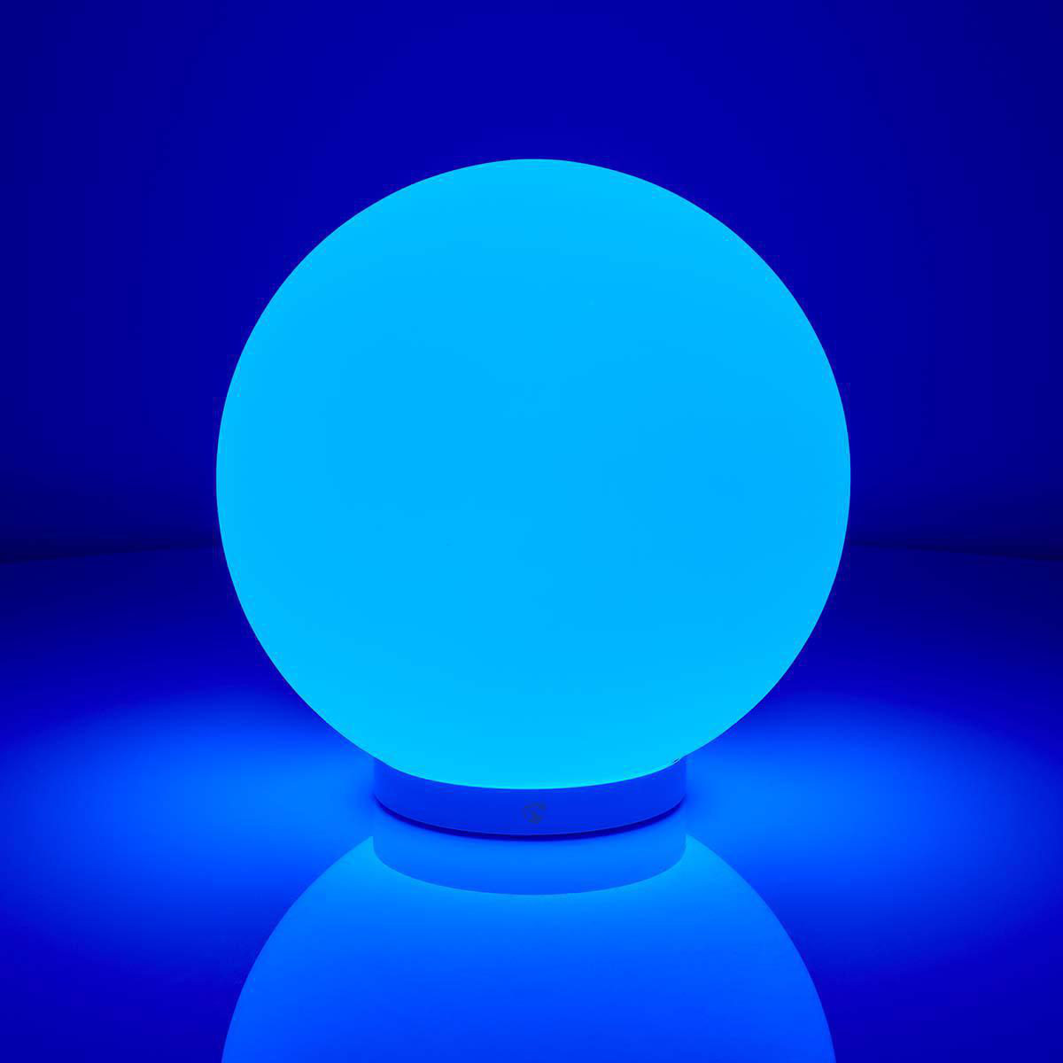Una lampada a sfera blu brillante su sfondo blu scuro, che riflette la luce.