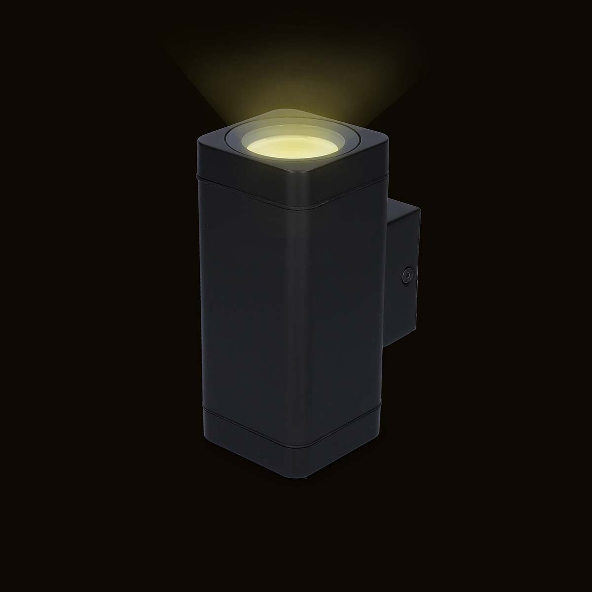 Eine schwarze, quadratische Außenleuchte, die gelbes Licht vor einem schwarzen Hintergrund ausstrahlt.
