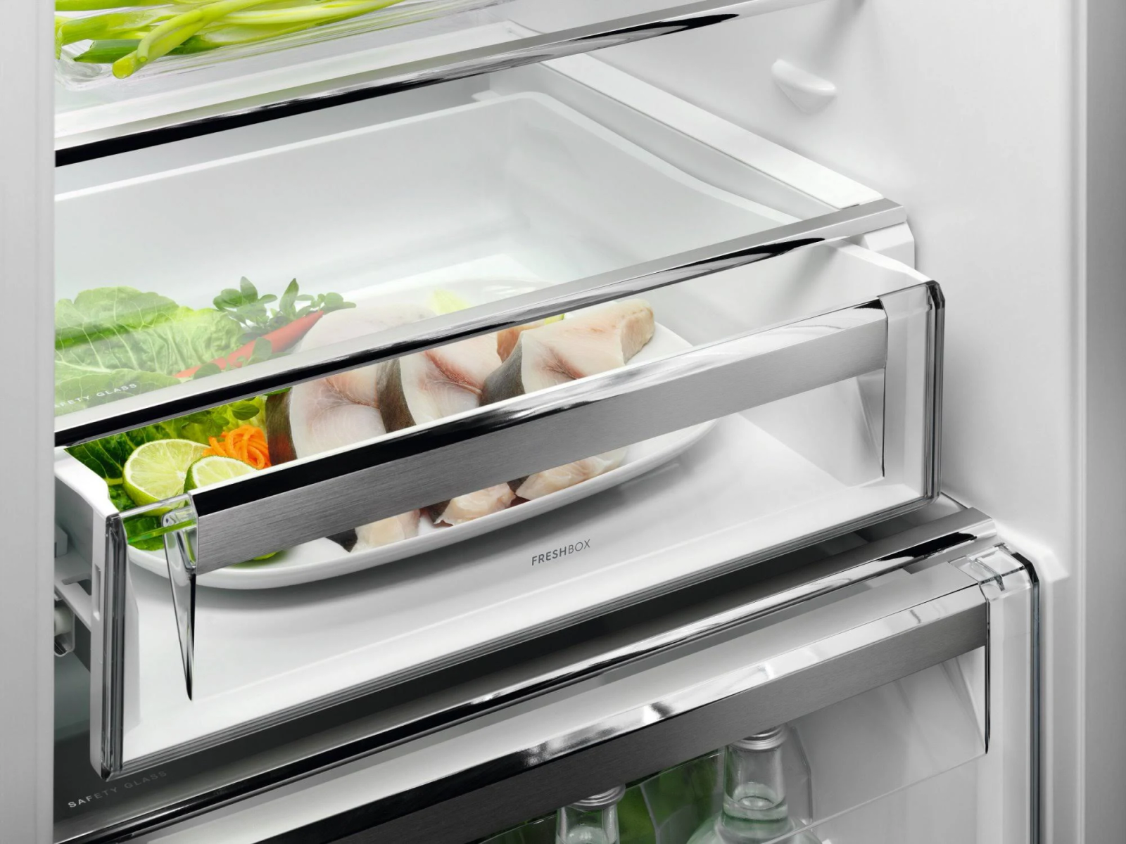Dentro de un refrigerador: un cajón freshbox lleno de alimentos, incluyendo pescado y verduras.