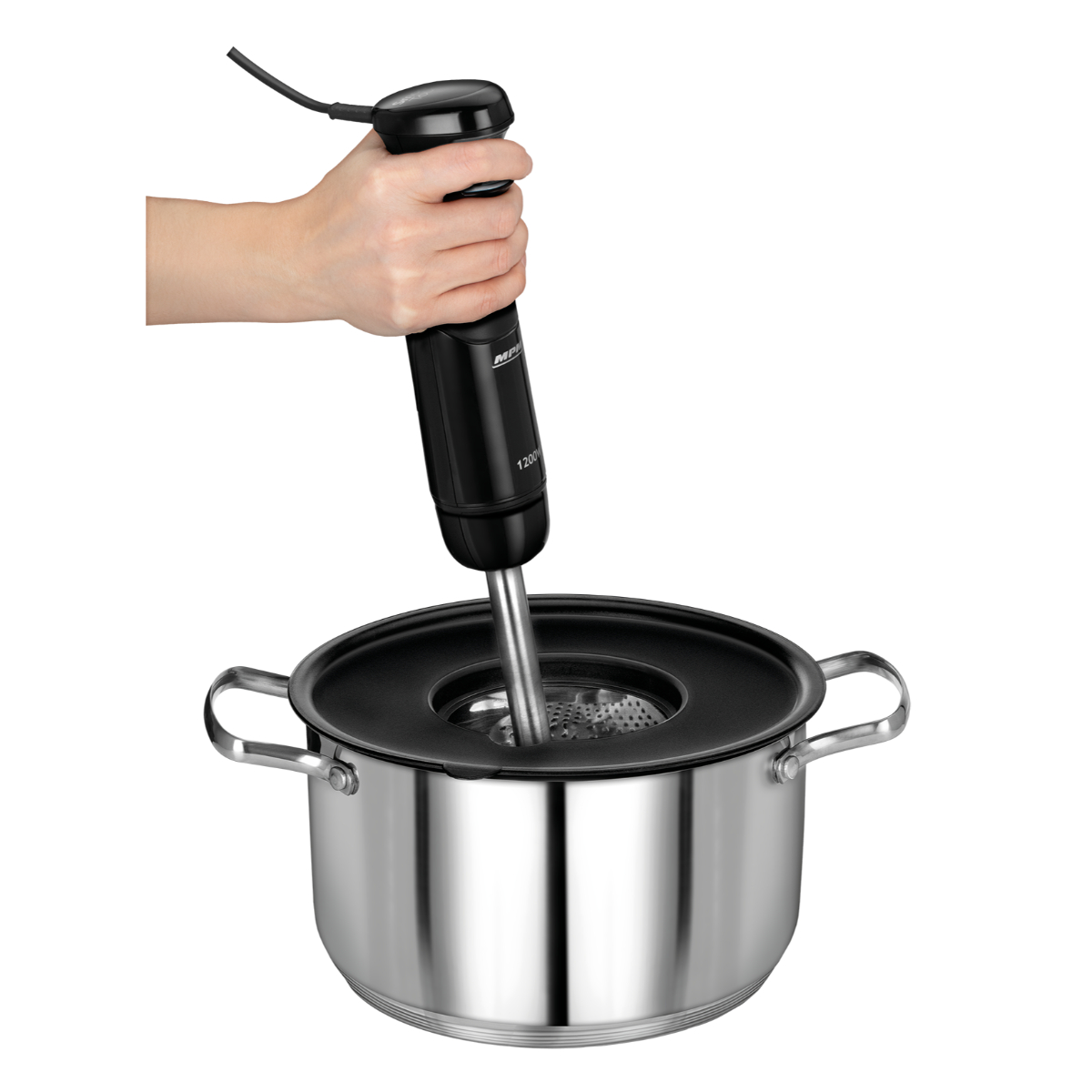 Una mano sosteniendo una batidora de inmersión negra en una olla de acero inoxidable.