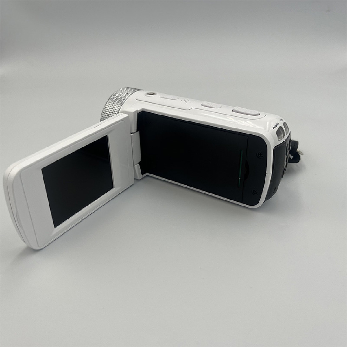 Biała kamera z otwartym ekranem wyświetlającym czerń. Posiada przyciski i srebrny obiektyw.