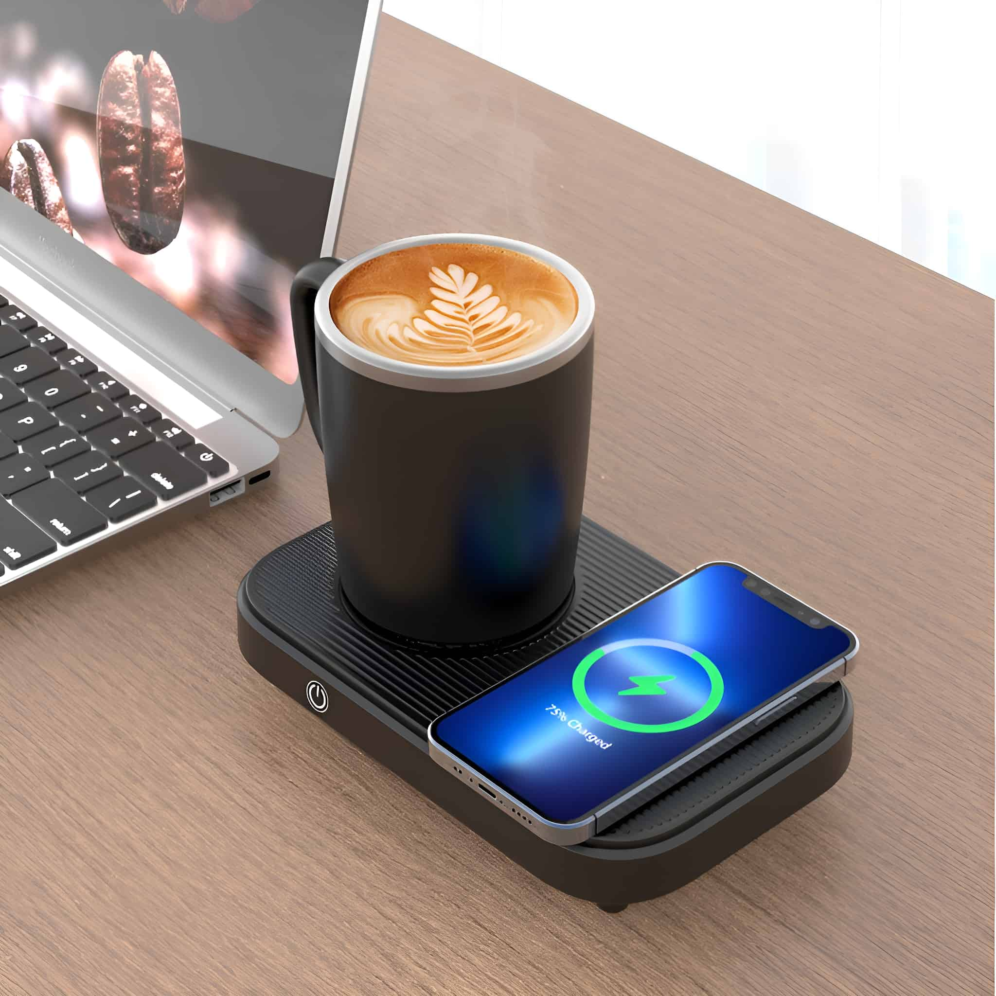 Eine Tasse mit Latte-Art auf einem kabellosen Ladegerät mit einem ladenden Telefon. Ein Laptop im Hintergrund.