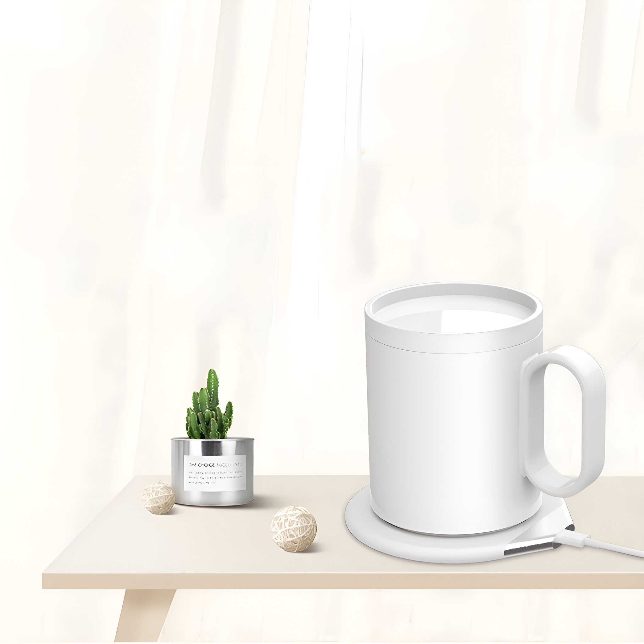Weißer Becher auf einem weißen Wärmer, mit einem kleinen Kaktus und dekorativen Kugeln auf einem Tisch.