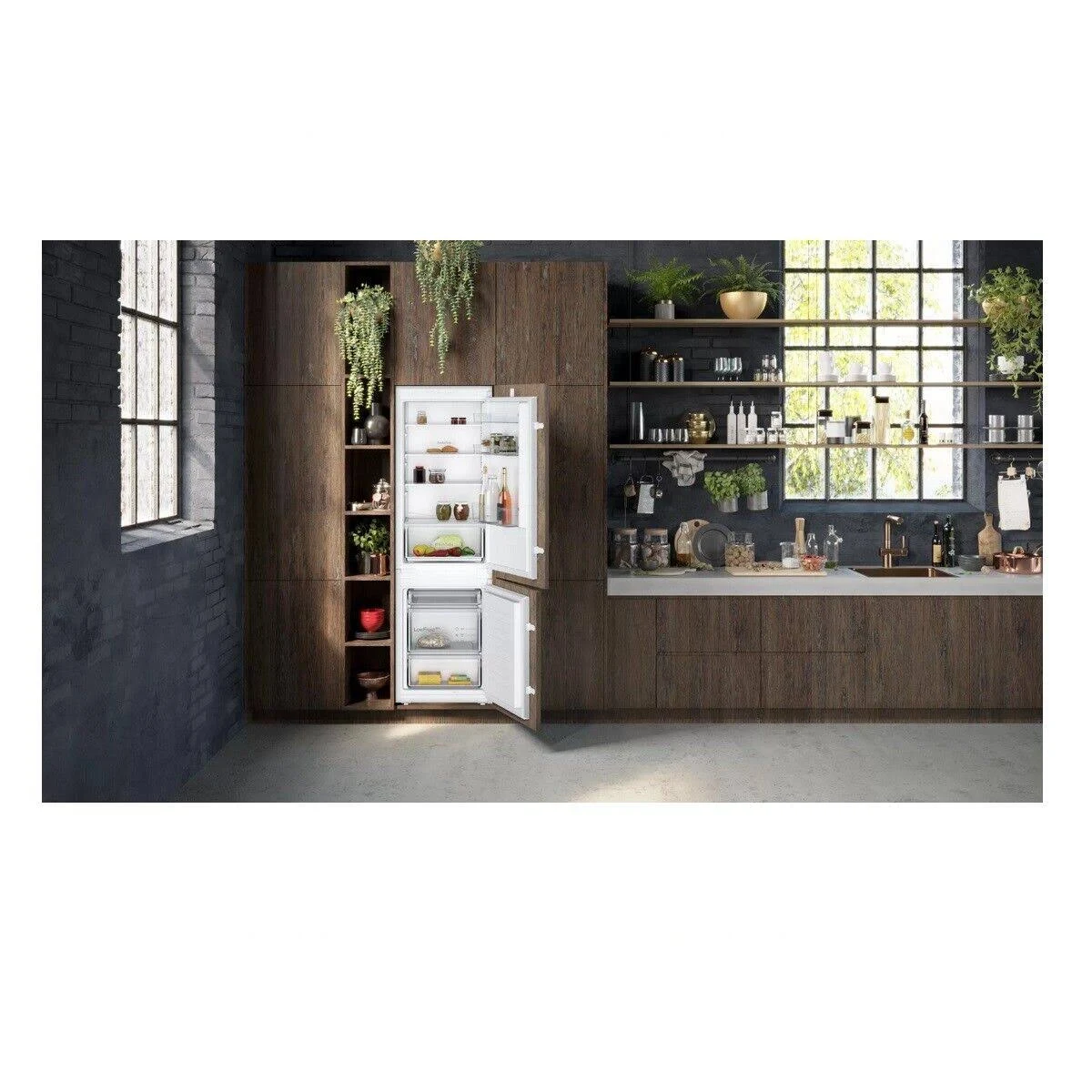 Eine Küche mit offenem Kühlschrank in einem dunklen Holzschrank.