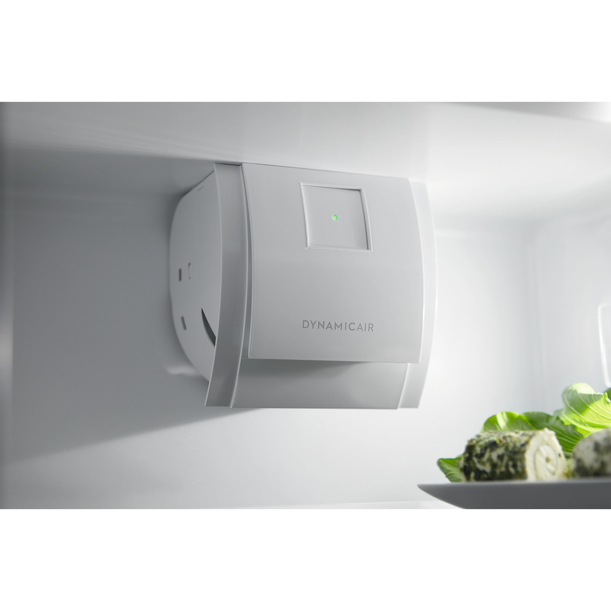 Purificatore d'aria DynamicAir bianco all'interno di un frigorifero con cibo verde.