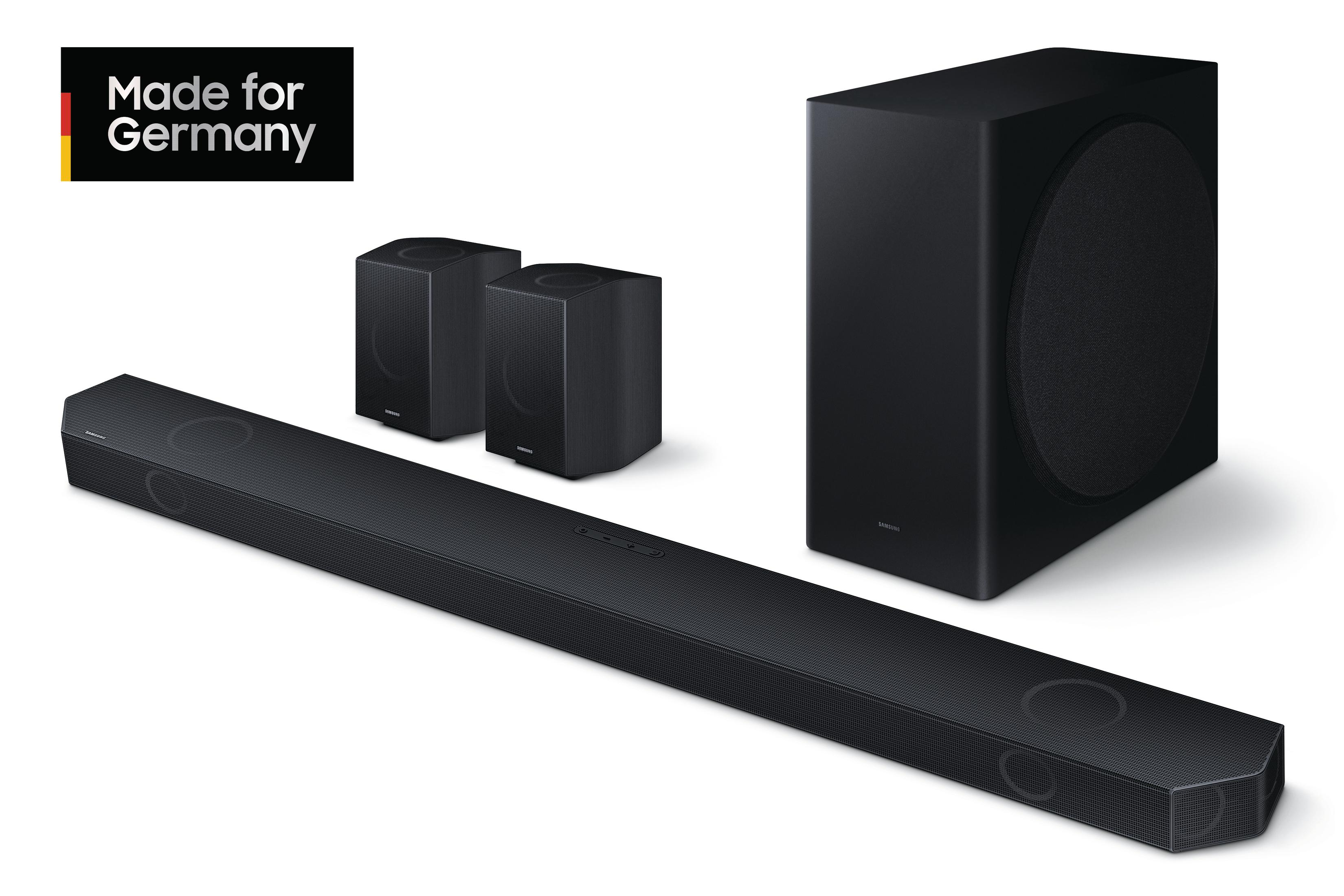 Schwarzes Samsung Soundbar-System. Soundbar, Subwoofer und zwei Lautsprecher auf weißem Hintergrund.