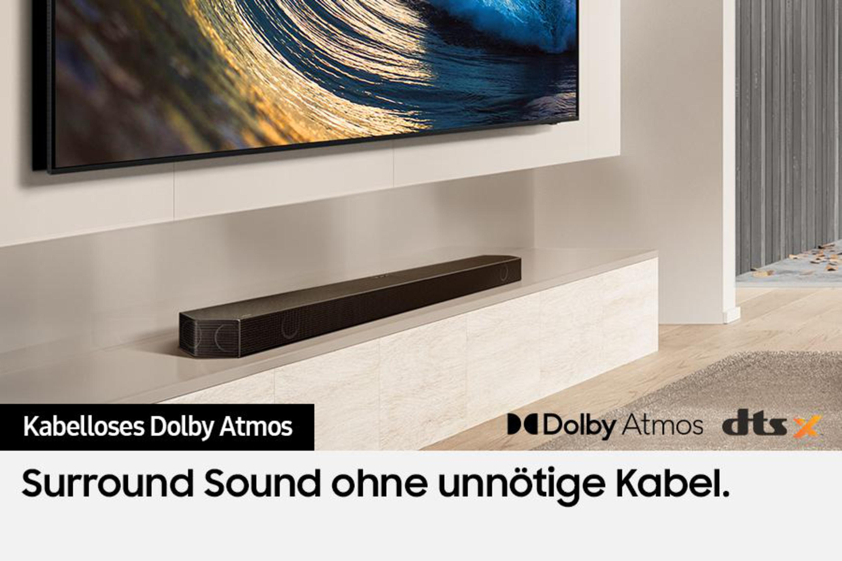 Soundbar mit Dolby Atmos- und DTS:X-Labels, auf einem weißen Schrank, mit einem Fernseher.