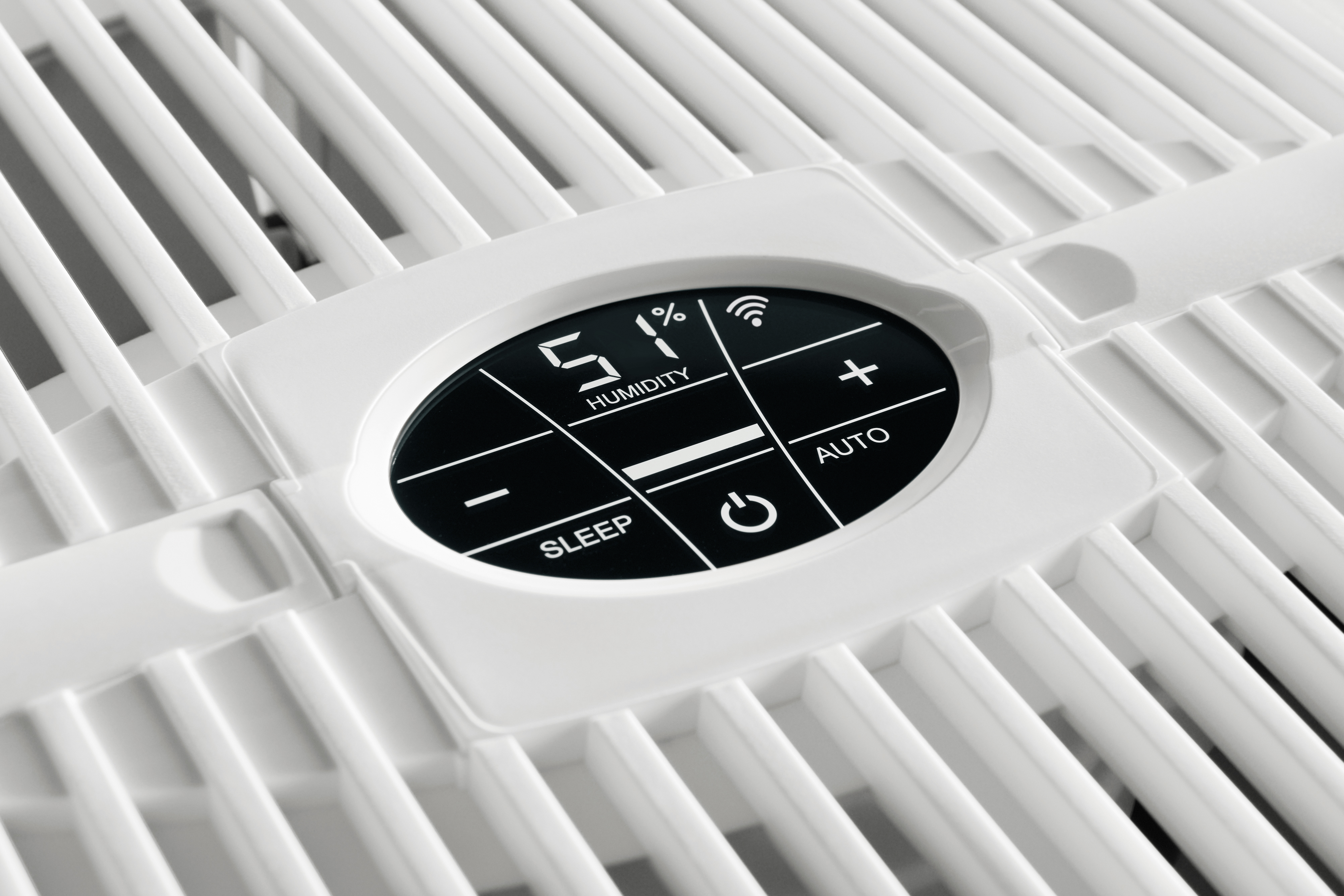 Zbliżenie białego panelu sterowania oczyszczacza powietrza. Wyświetla wilgotność, Wi-Fi i przyciski sterowania.