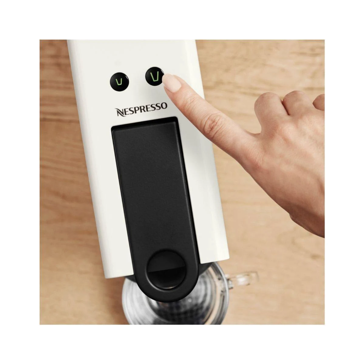 Osoba naciska przycisk na białym ekspresie do kawy Nespresso.