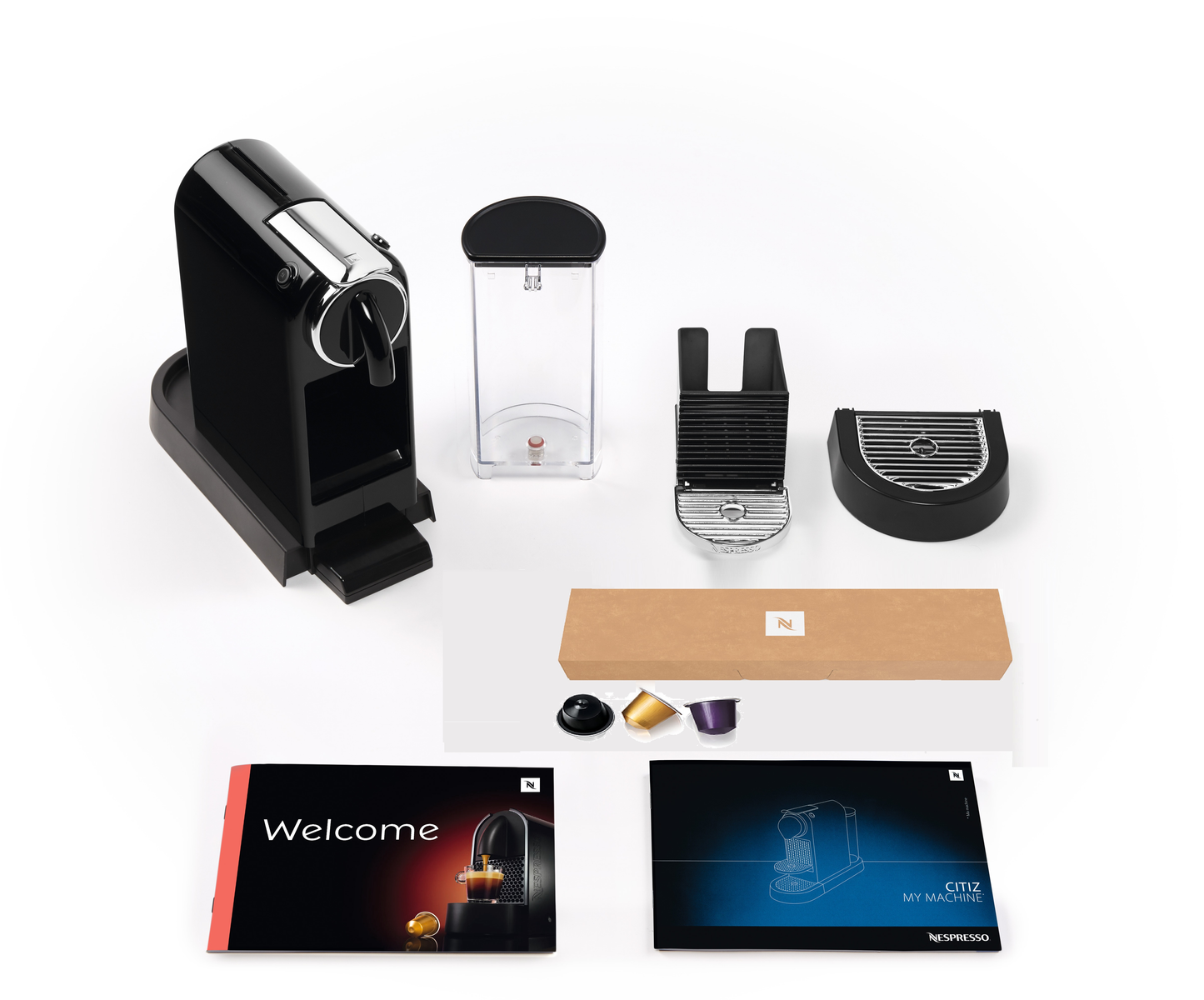 Czarny ekspres do kawy Nespresso i akcesoria. Przedmioty znajdują się na białej powierzchni.