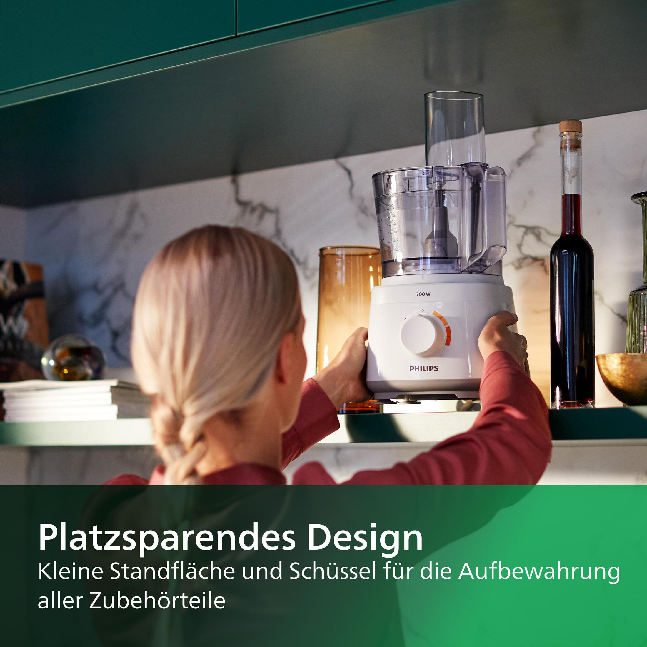 Eine Frau verstaut einen weißen Küchenroboter. Der grüne Text lautet: 
