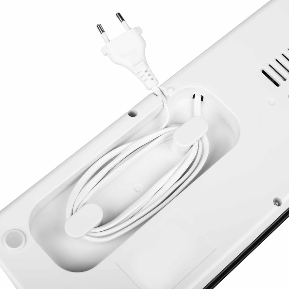Weißer Stecker und Kabel ordentlich in einem weißen Gerät verstaut.
