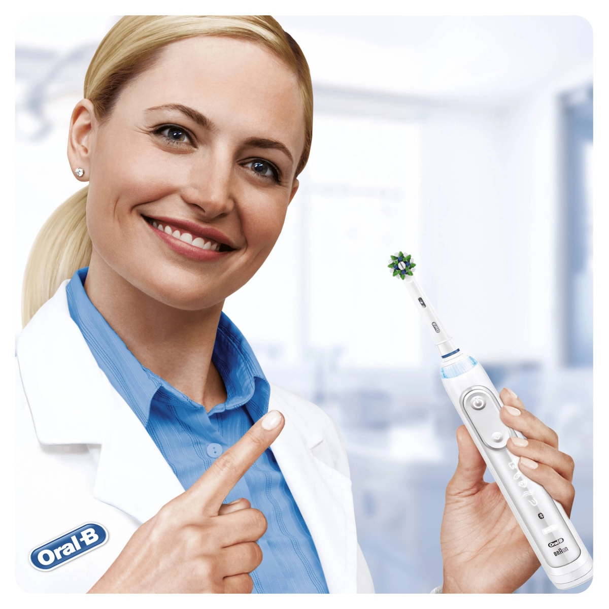 Una donna in camice bianco tiene uno spazzolino elettrico Oral-B bianco.