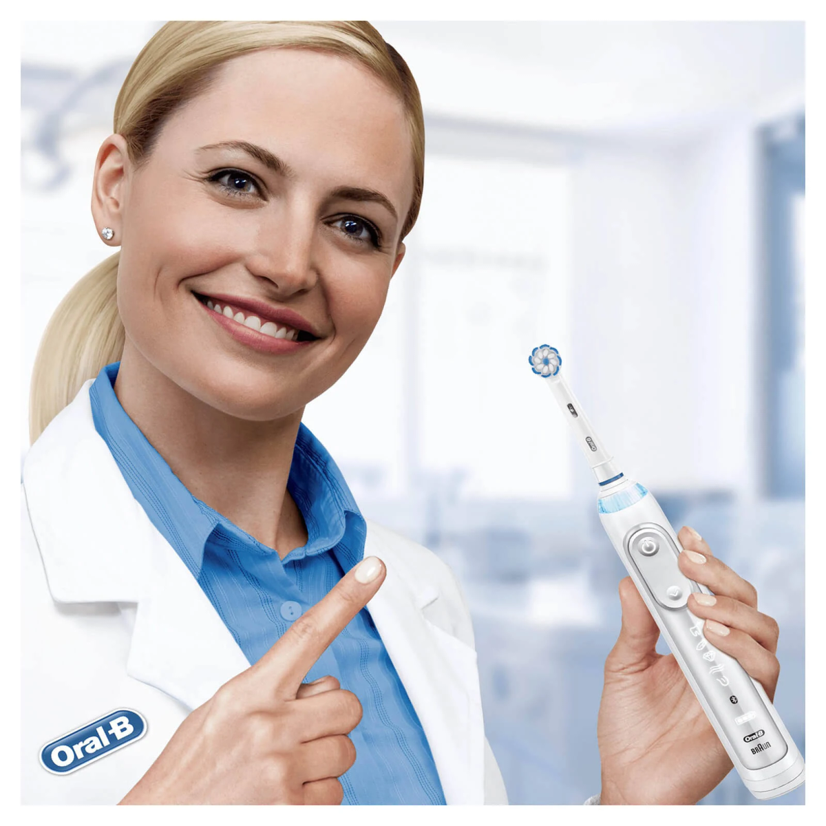 Donna bionda con camice da laboratorio che tiene e indica uno spazzolino Oral-B.
