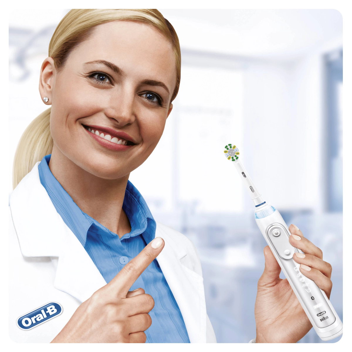 Donna che tiene uno spazzolino elettrico, indicandolo. Sfondo bianco.