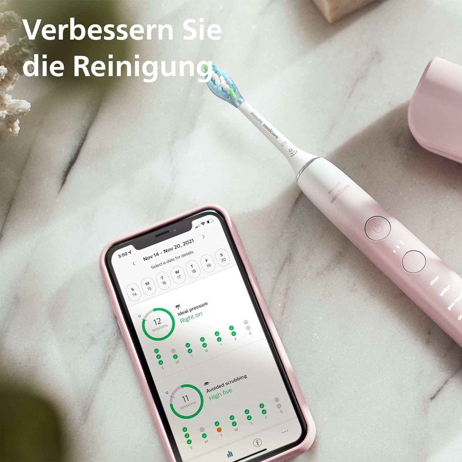 Spazzolino rosa con app su telefono che mostra dati spazzolatura. Superficie marmo.