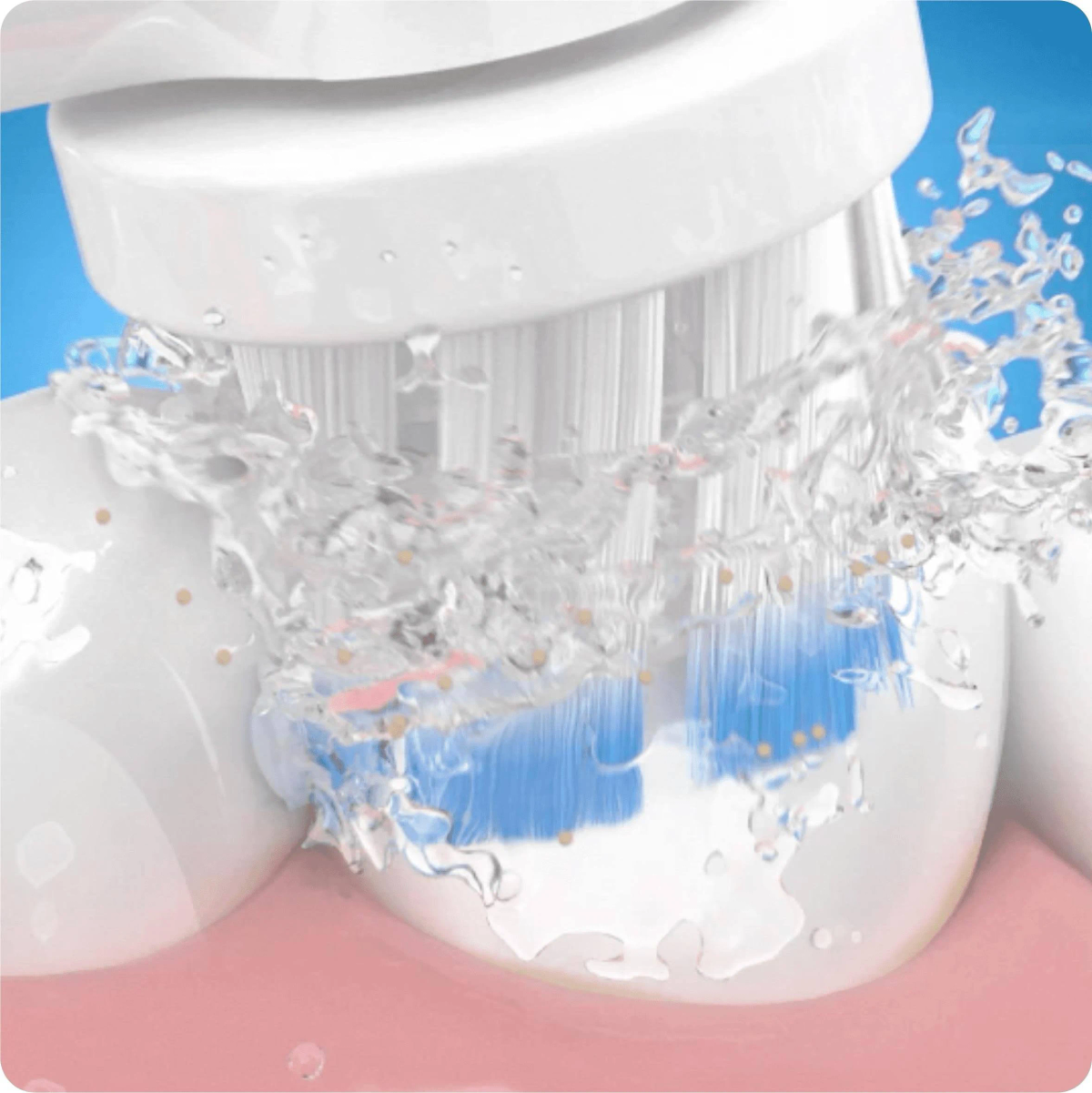 Primer plano de un cepillo de dientes eléctrico limpiando dientes, con agua rociando alrededor del cabezal.