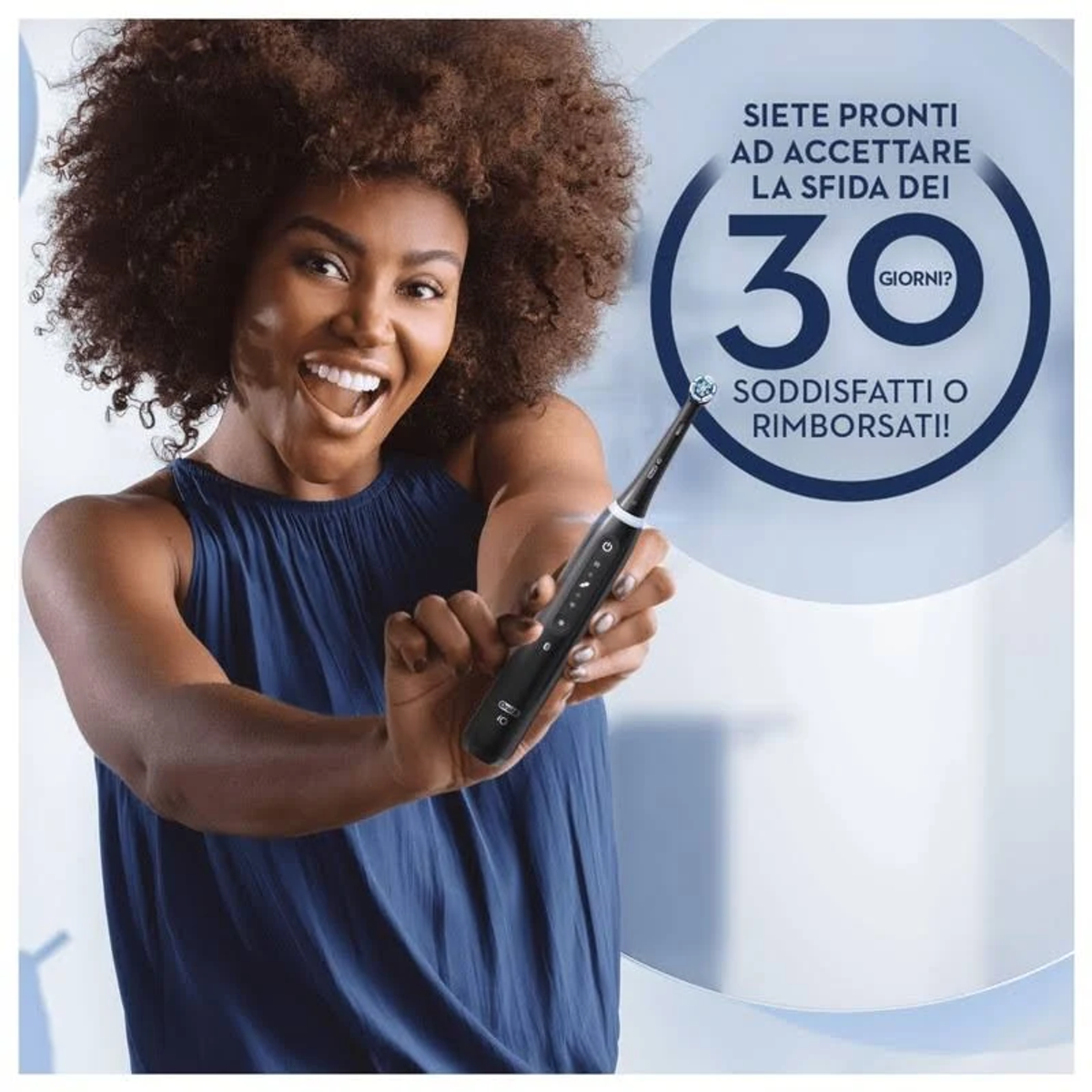 Una mujer sonriendo, sosteniendo un cepillo de dientes eléctrico negro. Texto en italiano, un círculo de 30 días.