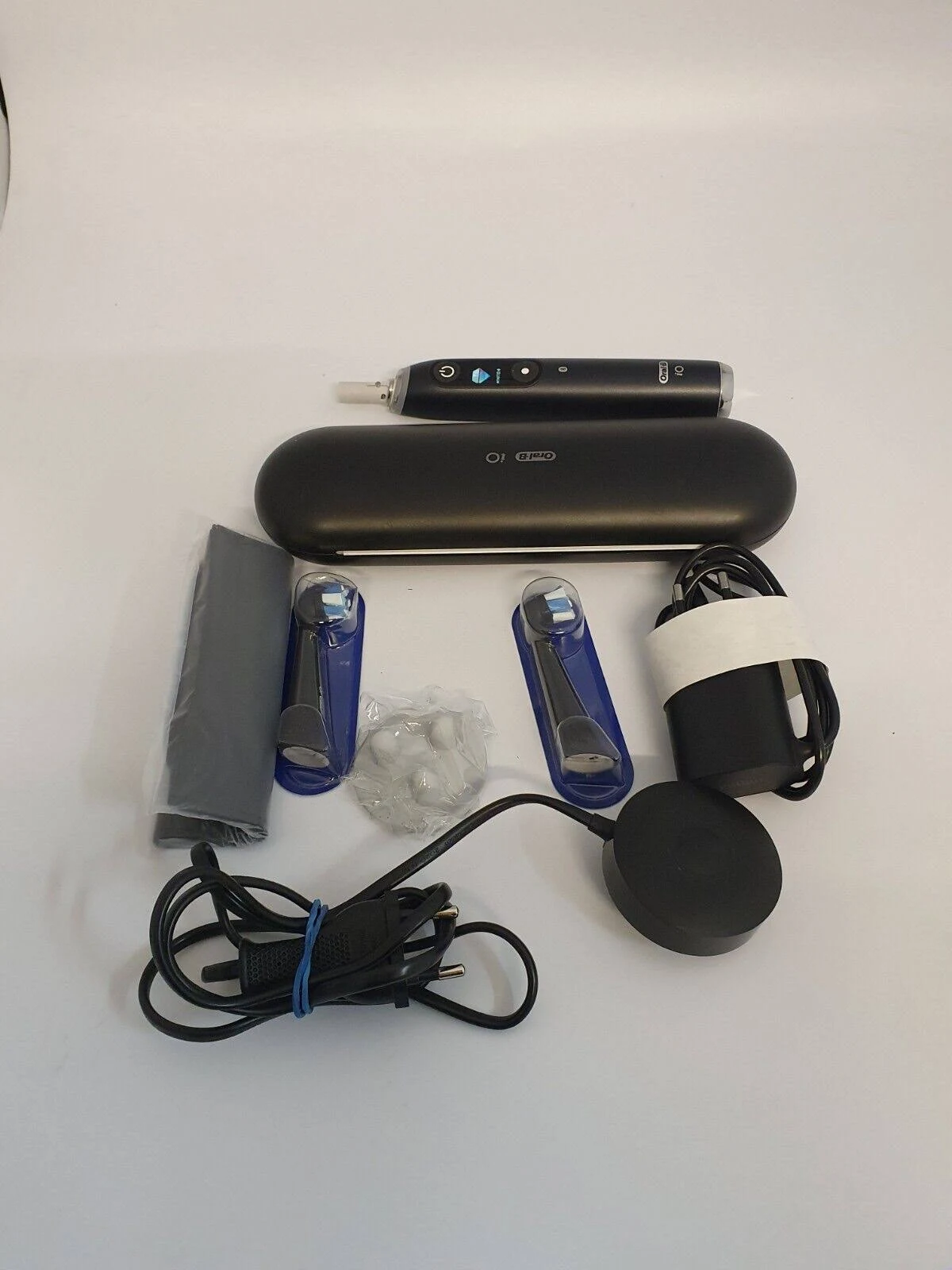 Set mit elektrischem Zahnbürstenzubehör. Enthält Zahnbürste, Ladegerät, Reiseetui und Bürstenköpfe.