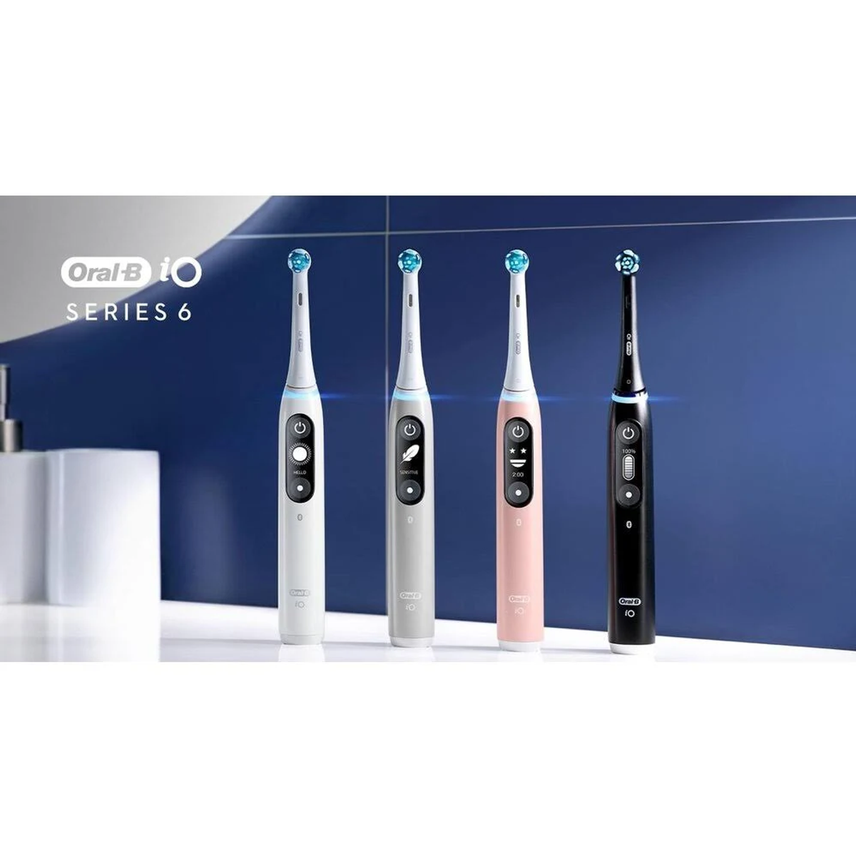 Four Oral-B iO Series 6 toothbrushes in white, gray, pink, and black. Blue background.