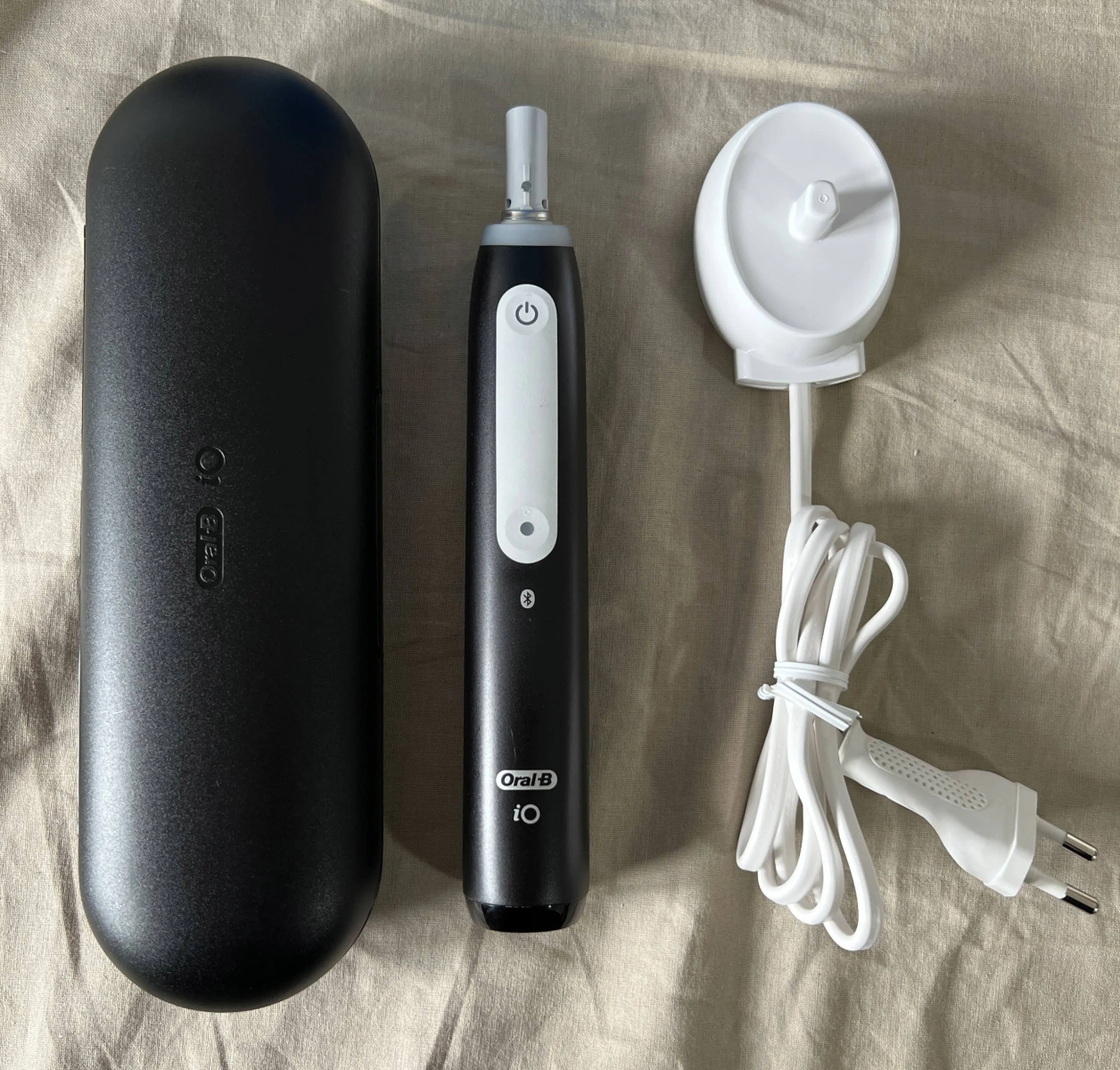 Szczoteczka elektryczna z etui i stacją ładującą.