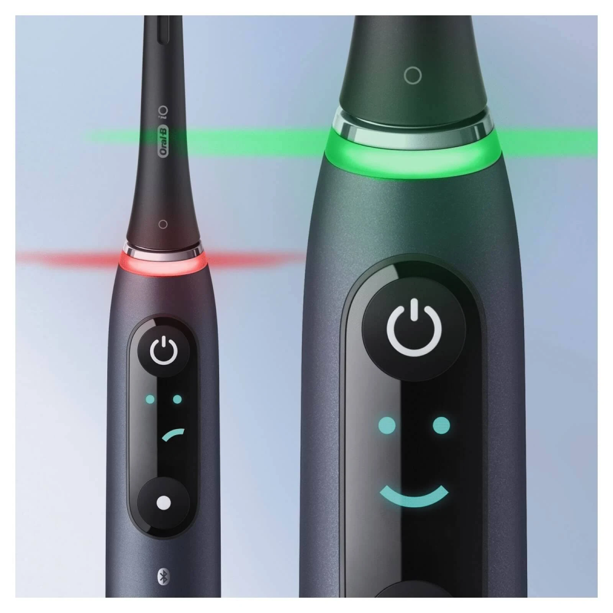 Dos vistas de cerca de cepillos de dientes eléctricos. Uno con luz roja, otro con luz verde. Botones.