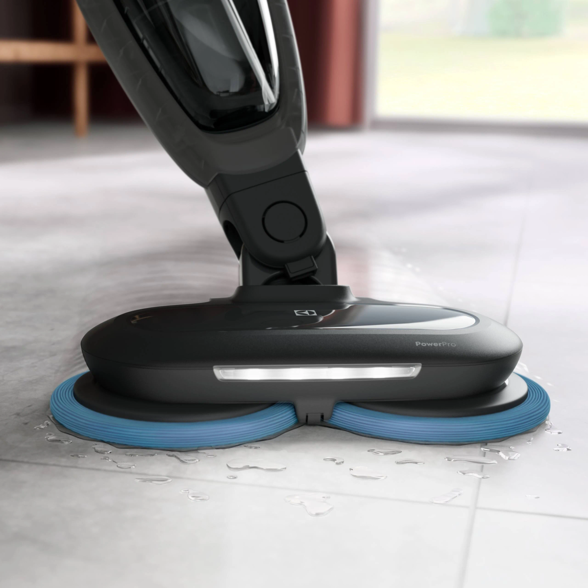 Un pulitore per pavimenti nero e blu sta pulendo un pavimento piastrellato bianco. Acqua visibile.