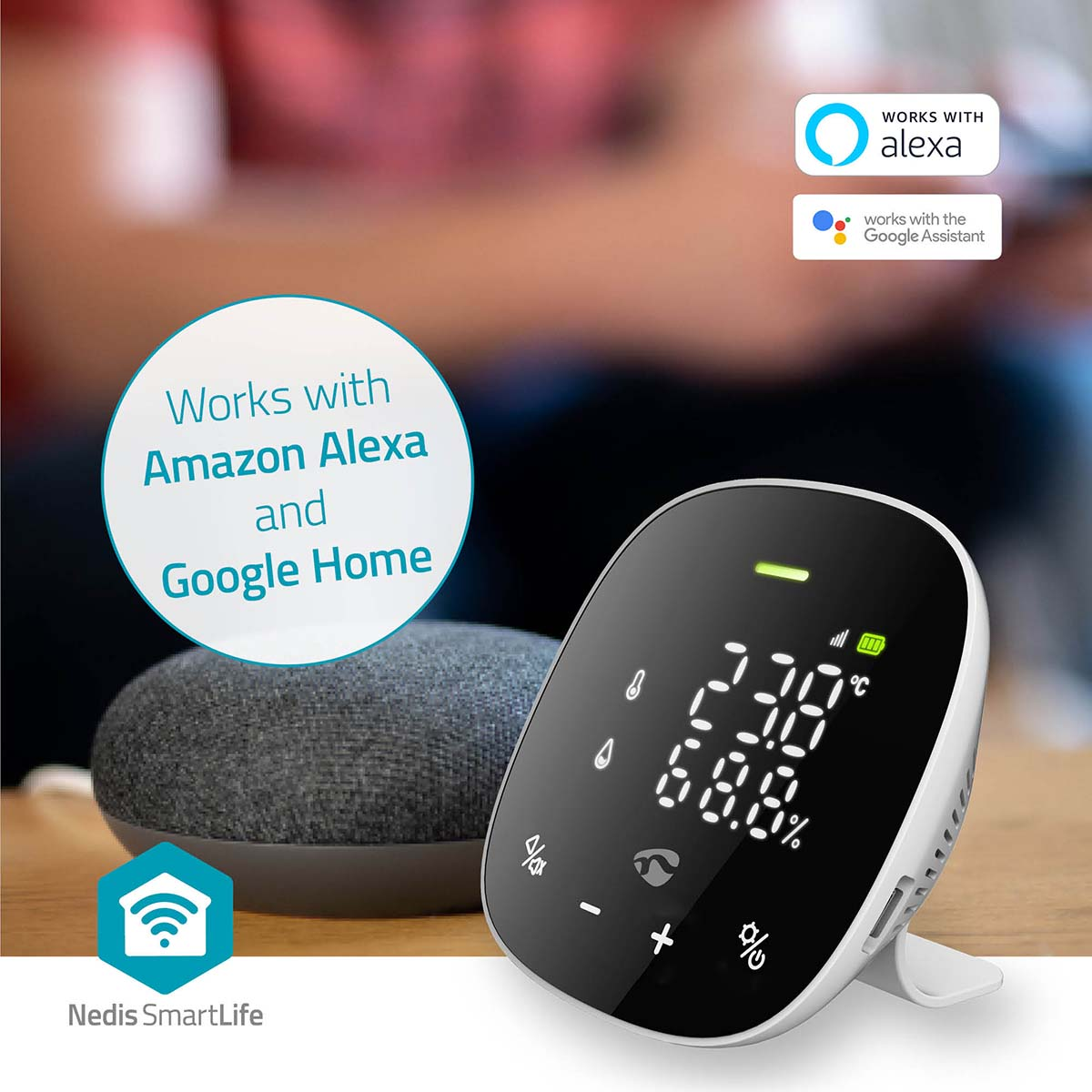Een zwart-wit smart home-apparaat met een scherm dat temperatuur en vochtigheid toont, naast een luidspreker.