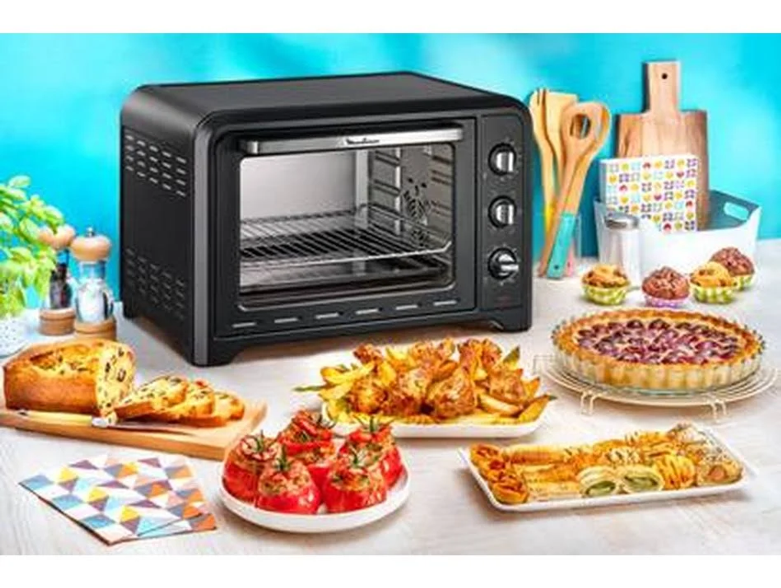 Un forno nero con vari piatti tra cui prodotti da forno e pomodori.