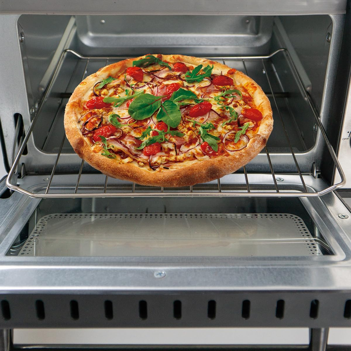 Pizza con condimenti su una griglia dentro un forno. È rotonda, con formaggio e verdure.