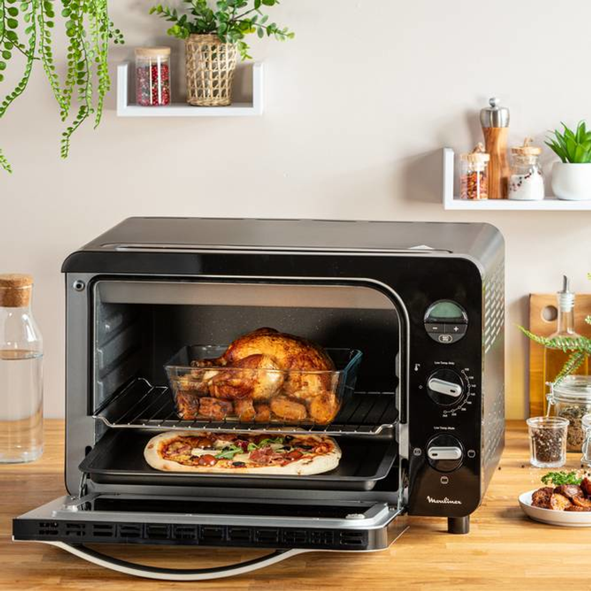 Forno nero con pollo arrosto e pizza all'interno, e cibo intorno.