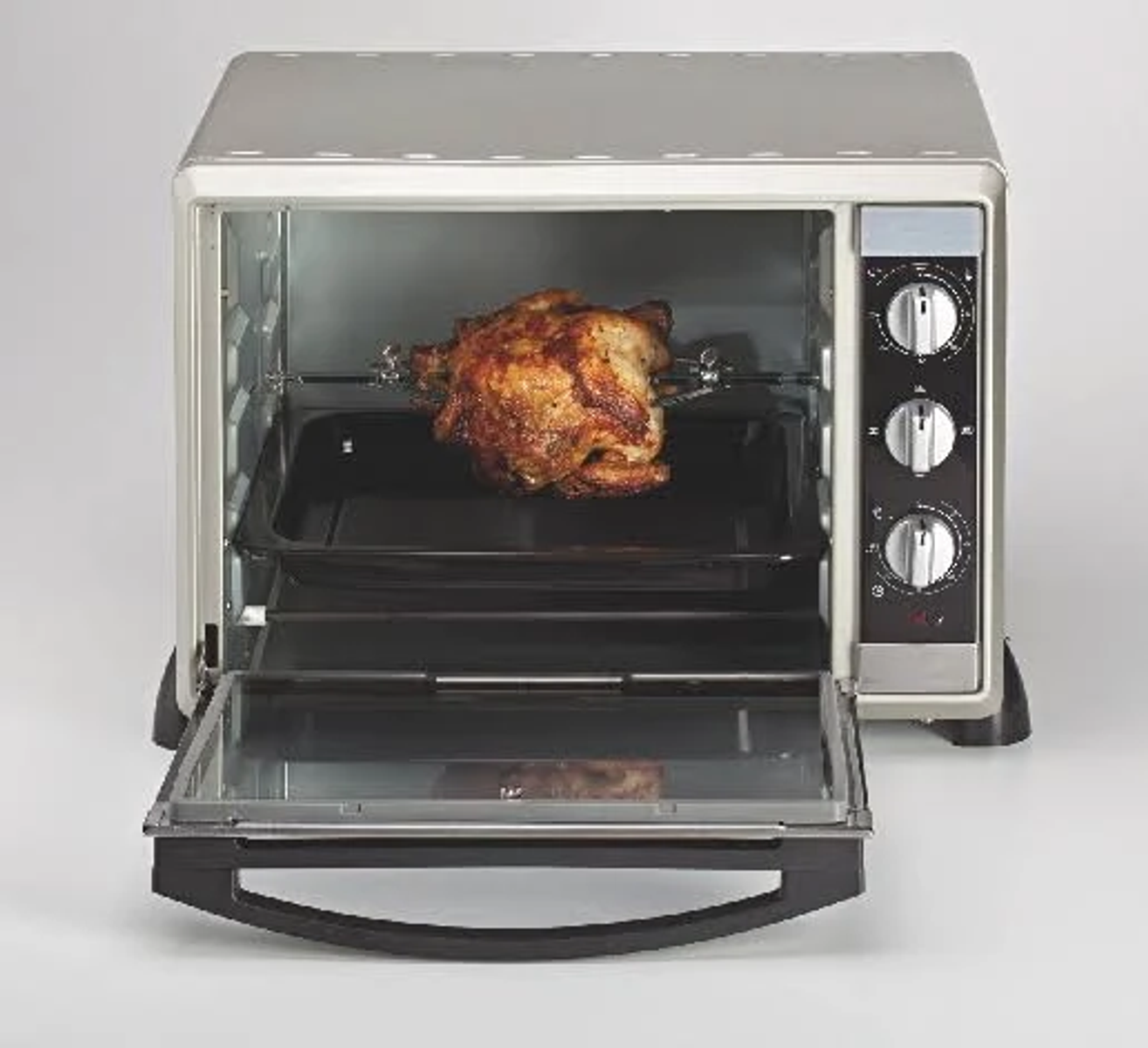 Srebrny piekarnik z kurczakiem z rożna w środku. Drzwi piekarnika są otwarte.