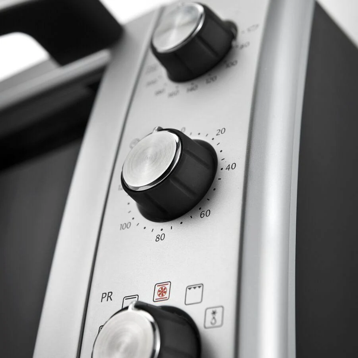 Zbliżenie pokręteł piekarnika, pokazujące ustawienia temperatury i funkcji.